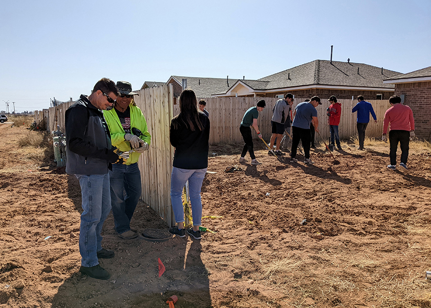 Mandry employees and other local volunteers helping build fence for Lubbock Habitat for Humanity